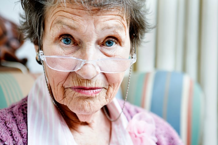 An older person is looking at the camera.