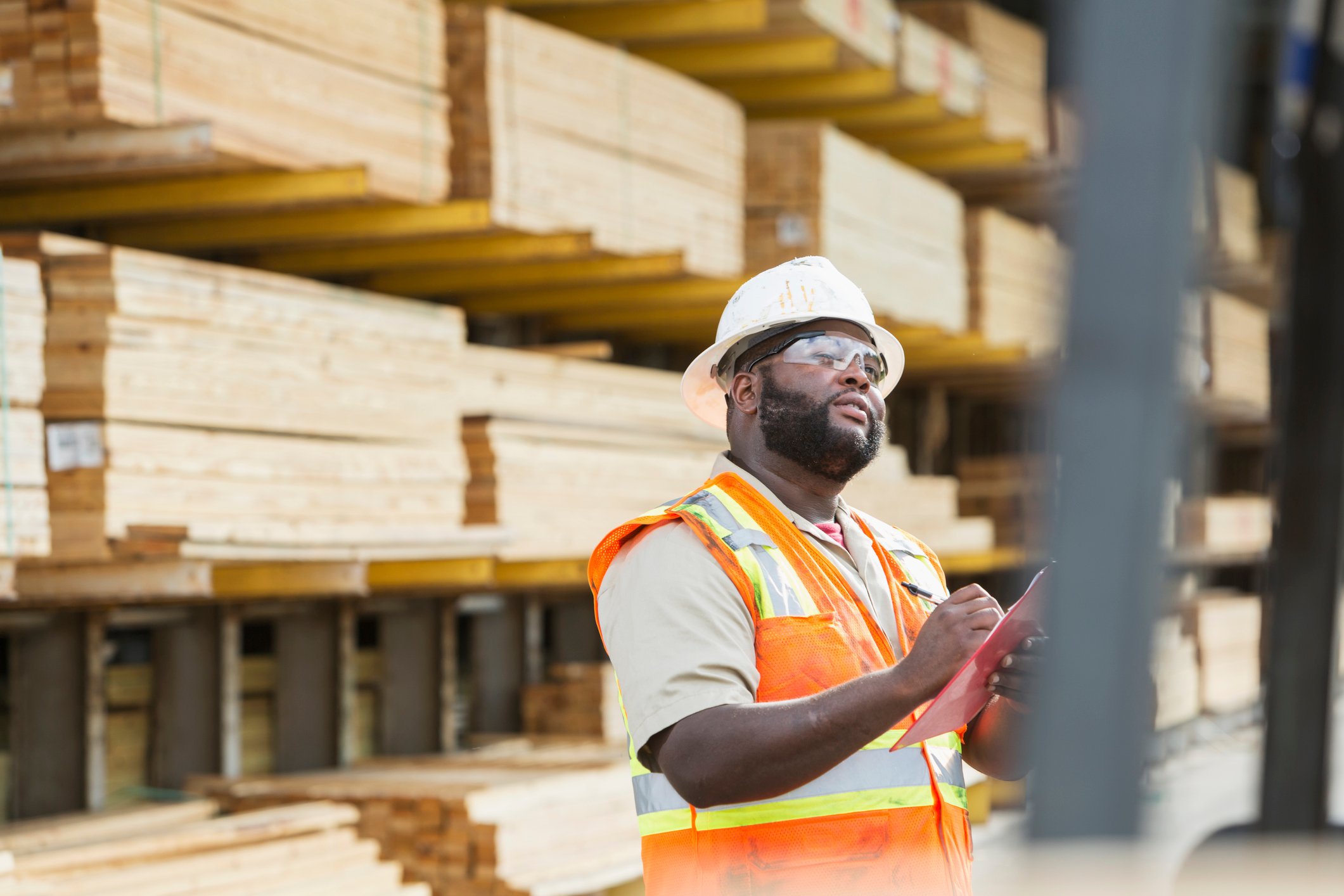 A worker assesses inventory in the lumber section of a store.