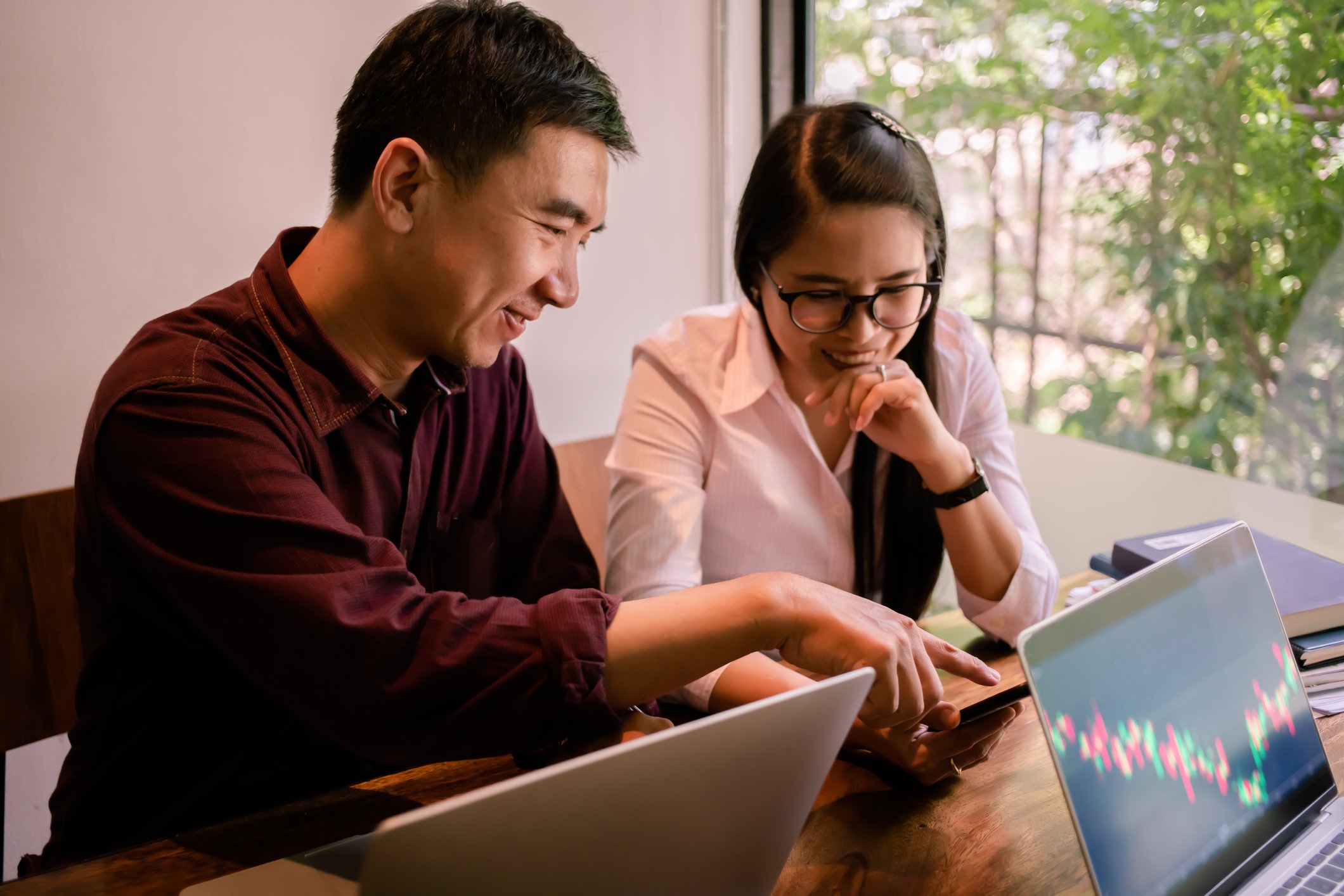 Two people in front of laptops.
