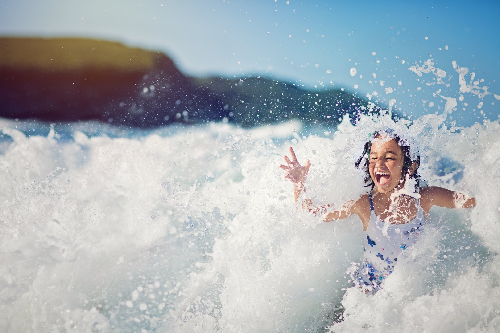 Child playing in ocean waves.