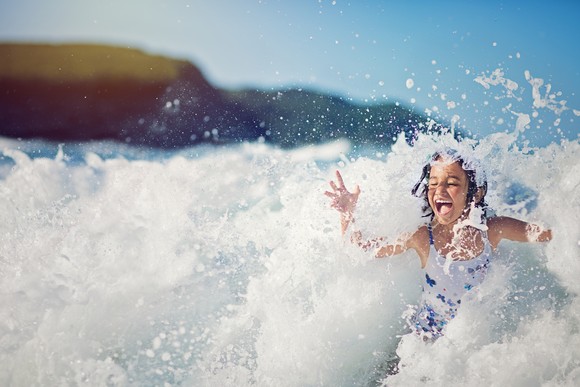 Child playing in ocean waves.