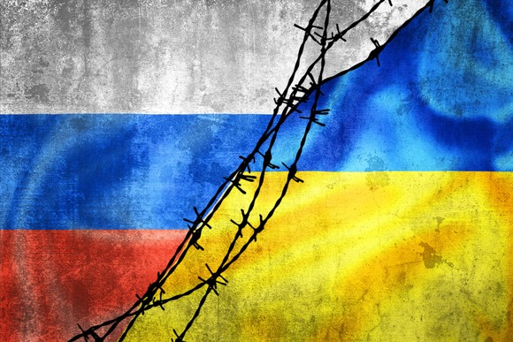 Ukraine and Russia flags with barbed wire in between.