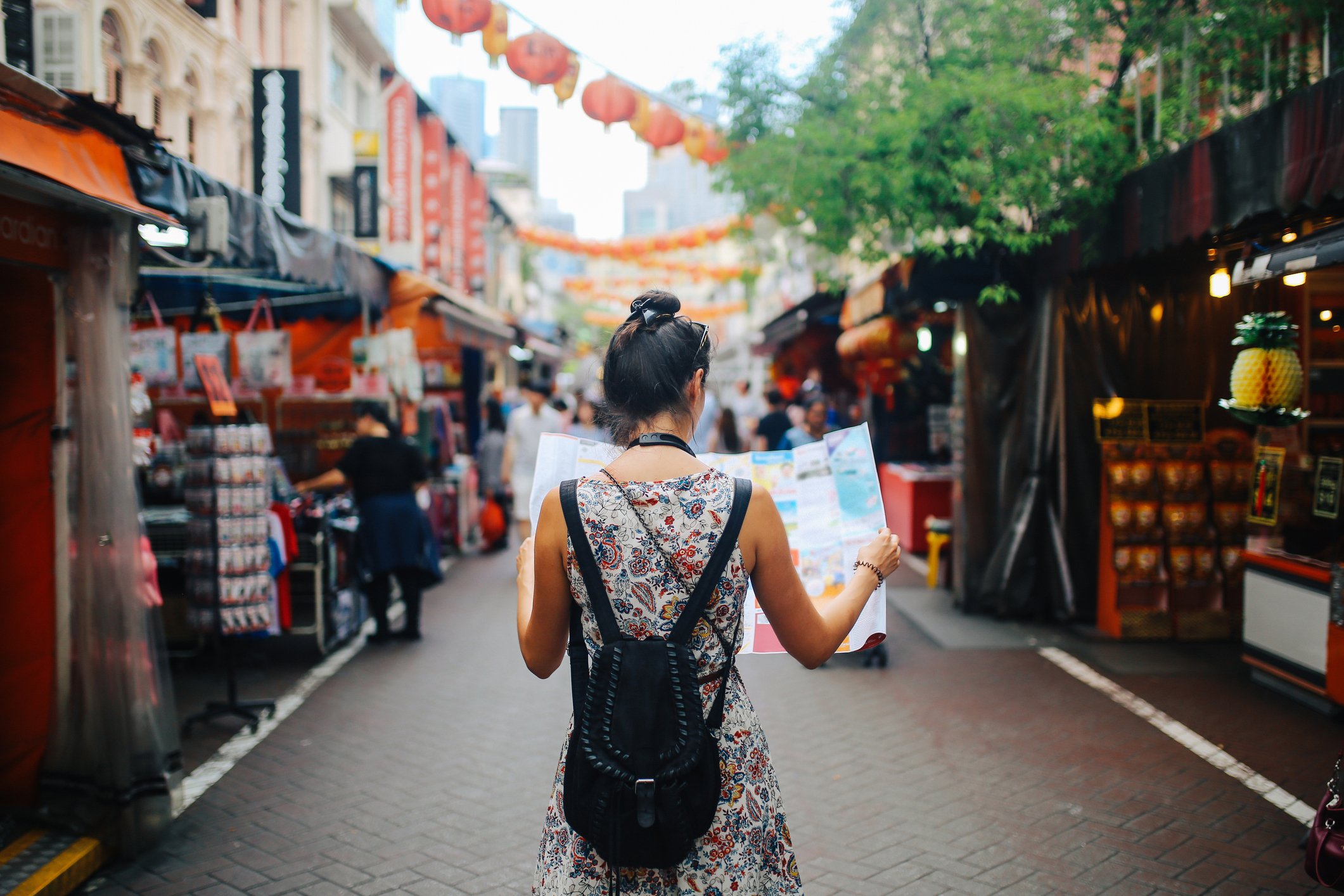 A tourist holding a map while walking in a city.