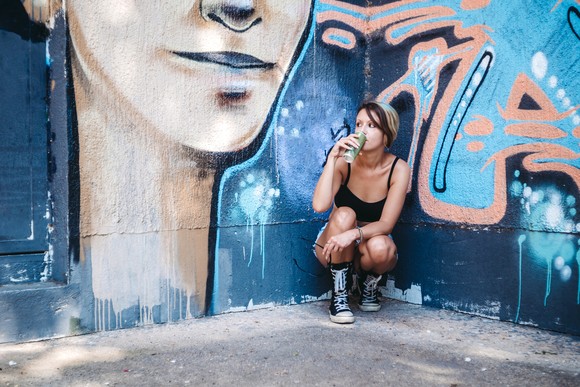 Young person drinking a canned energy drink.