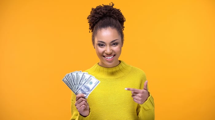 Woman holding money.