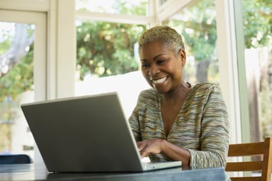 Happy person at home looking at computer.  