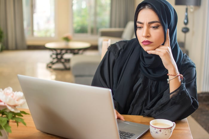 Serious person looking at laptop.