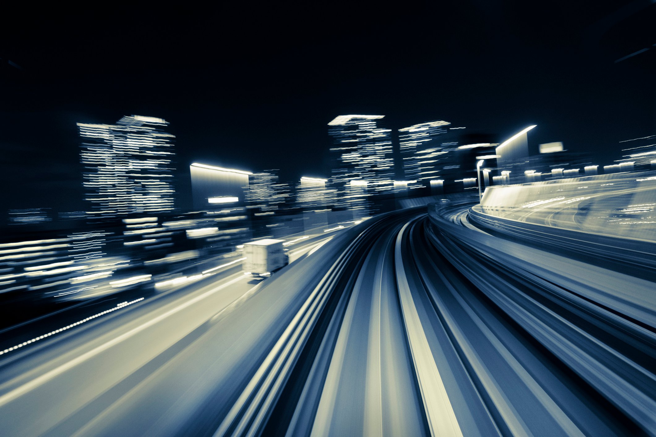 action shot of night scene of semi truck about to turn corner on city highway.