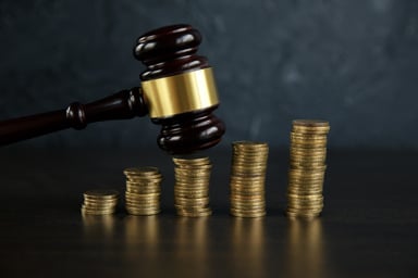 judge gavel over growing stacks of coins