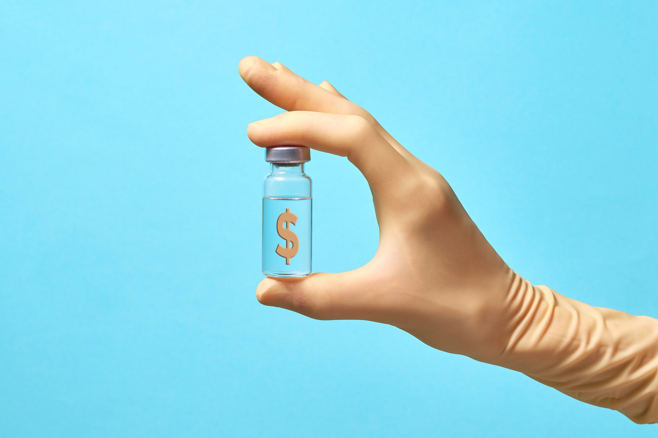 A hand holding a vaccine vial with a dollar sign in it.