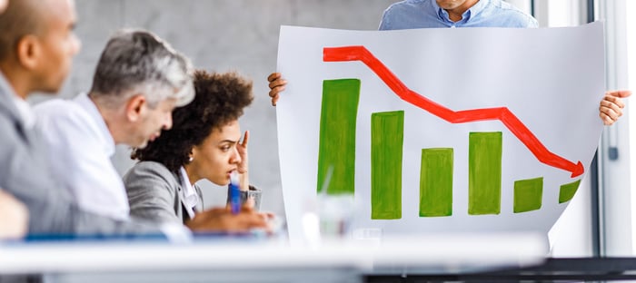 Group of investors looking at a stock market chart illustrating losses.