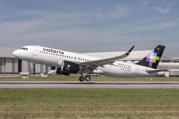 A Volaris jet landing on a runway.