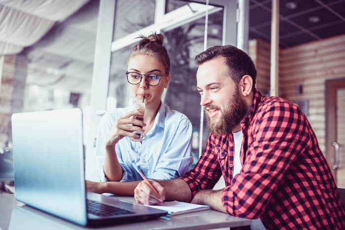 Man and woman looking at a laptop screen.