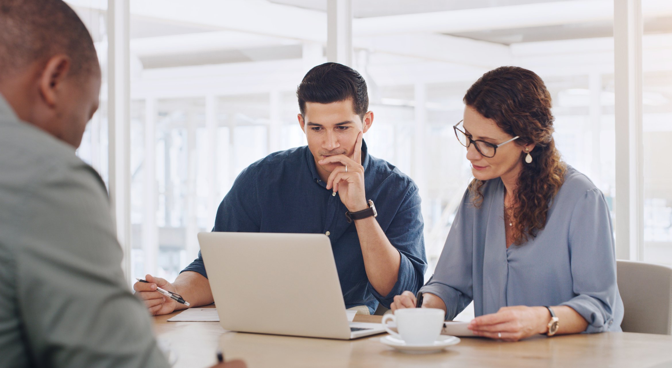 Two people looking at an open laptop.