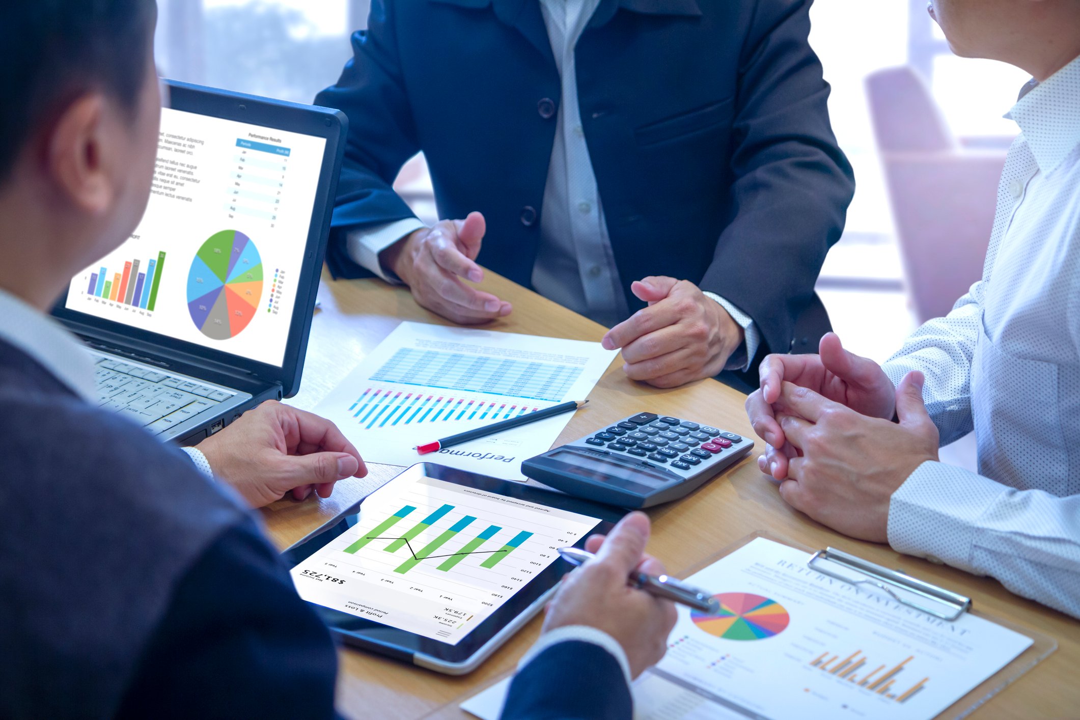 People sitting around table looking at charts.