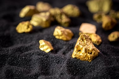 Gold nuggets on black sand.