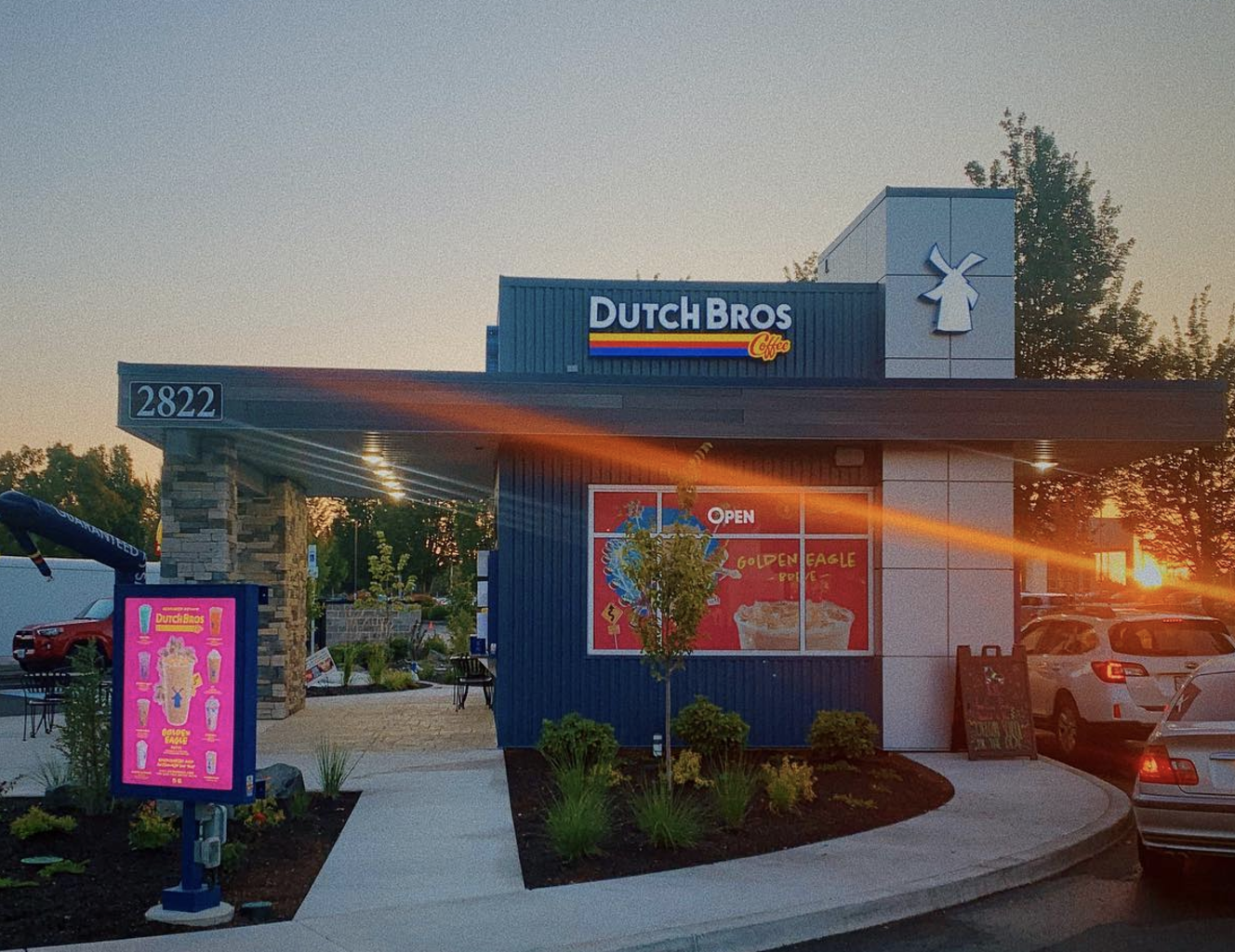 Cars waiting in drive-thru line at Dutch Bros store.