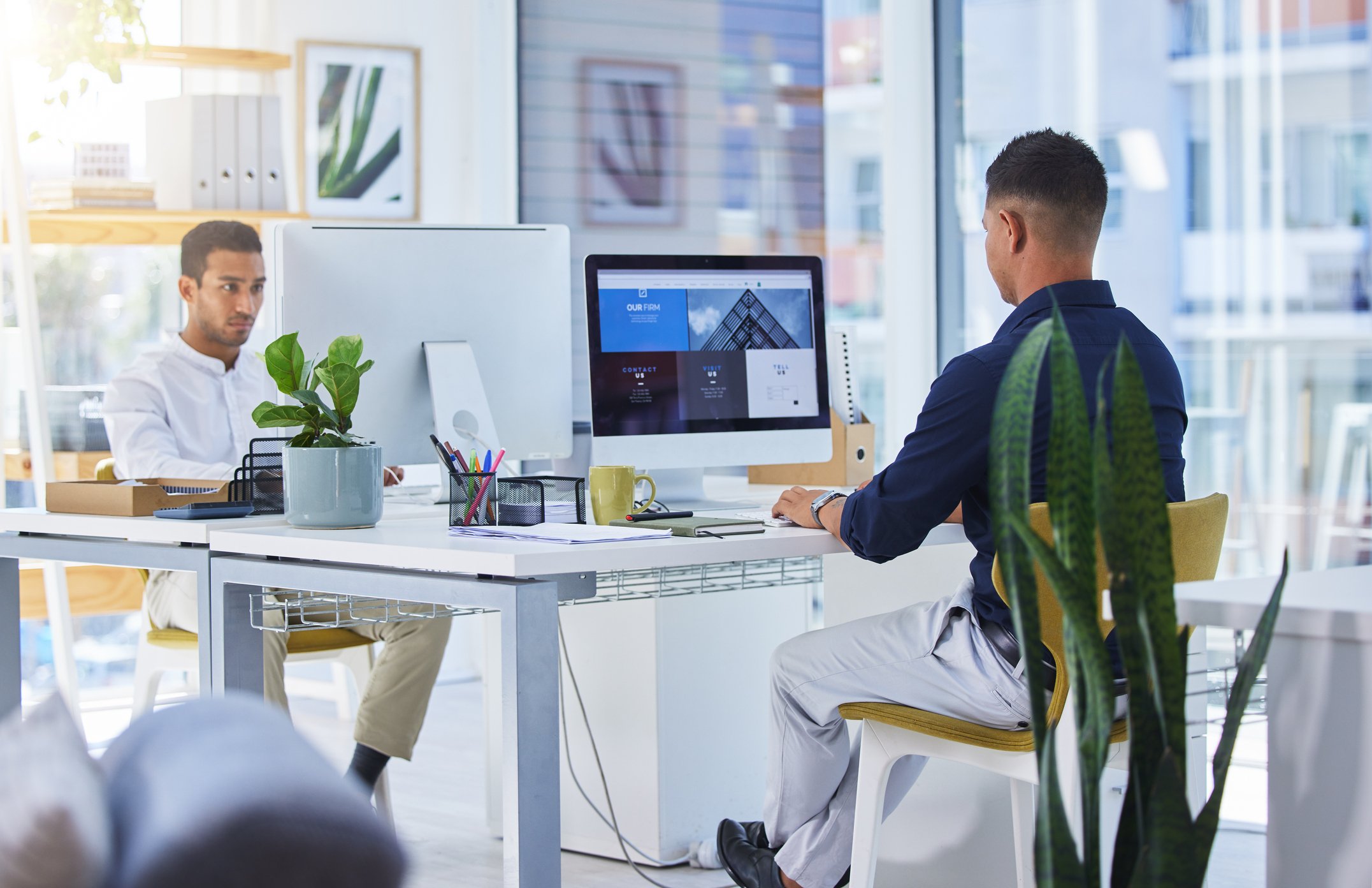 Two people working on their computers in a modern office.