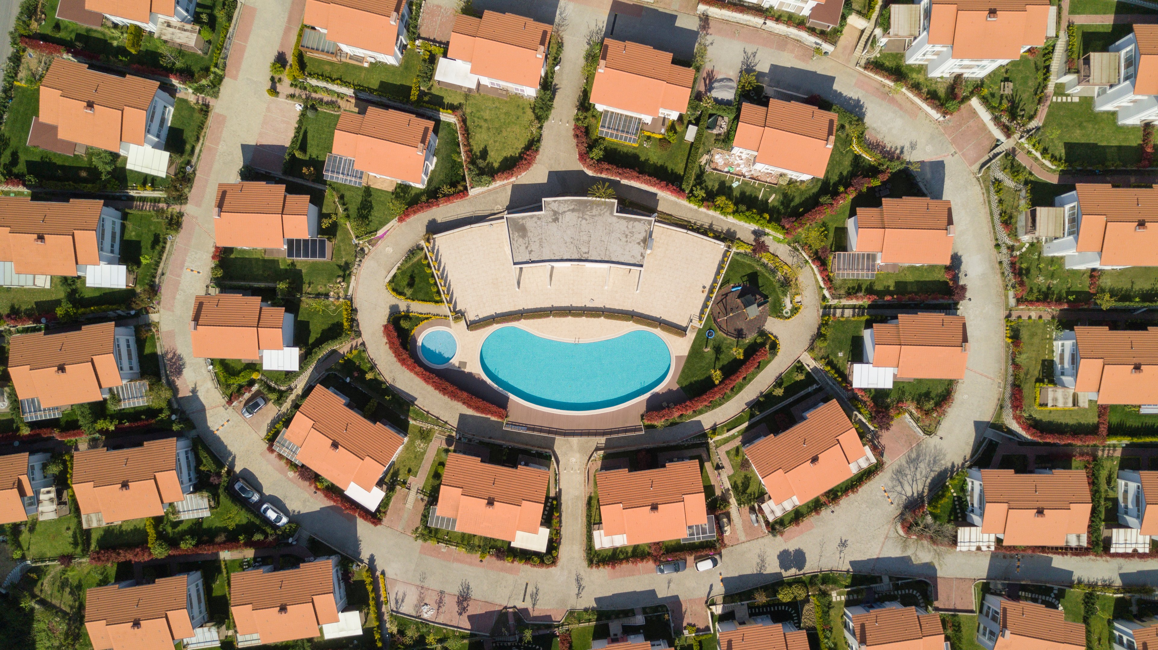 Drone shot of single-family rental community with pool in center.