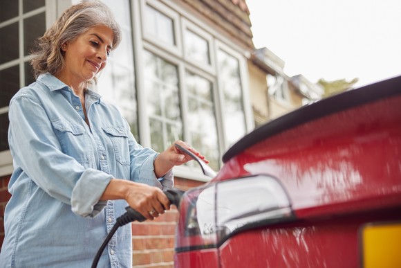 A driver charges a vehicle using an electric charging station.