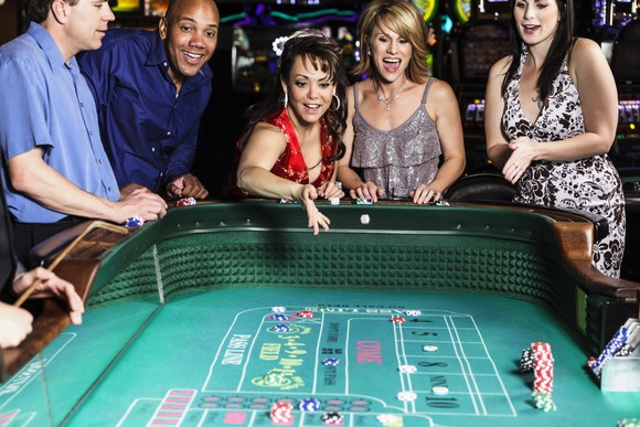 People making bets at a craps table in a casino.
