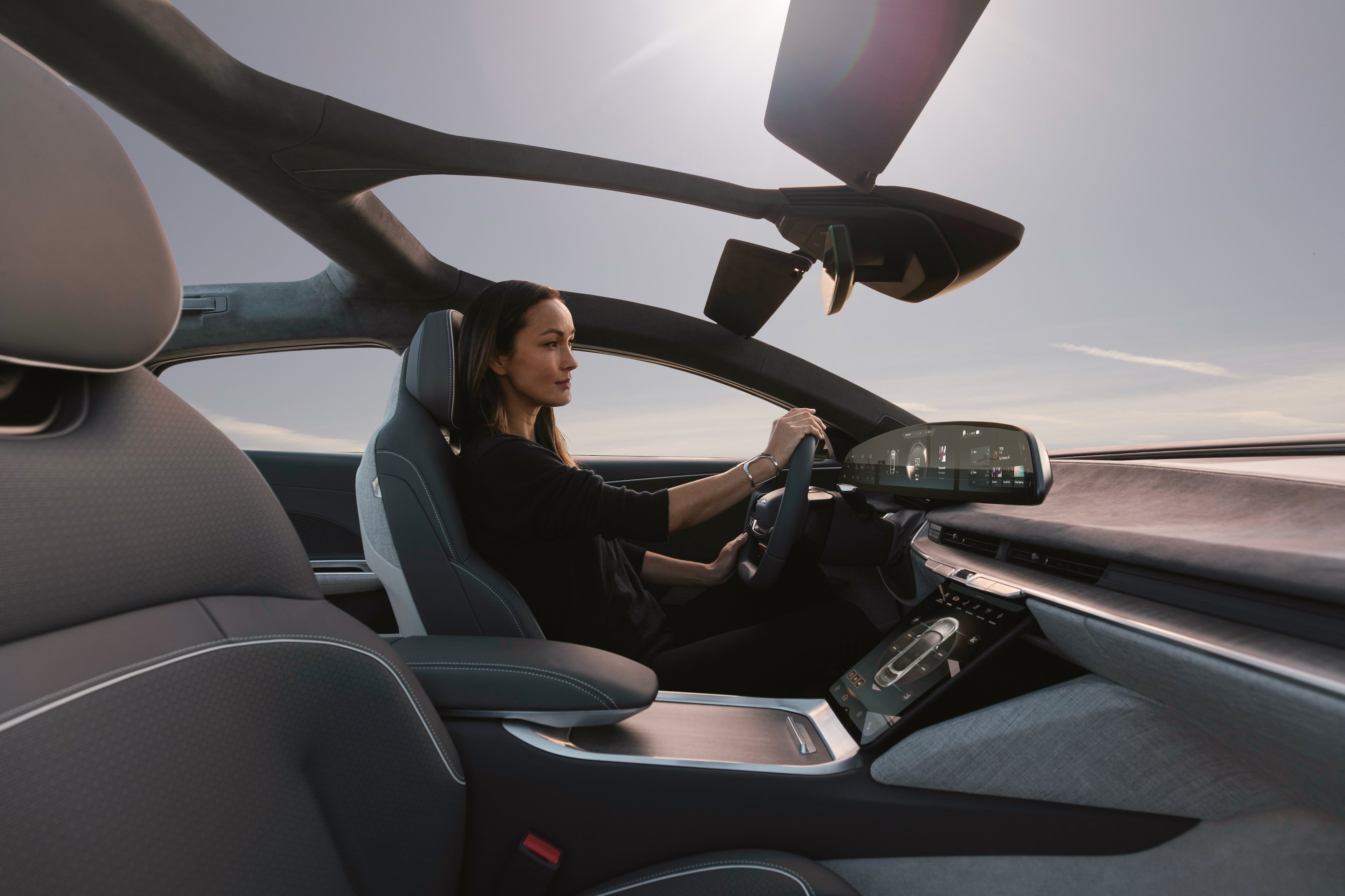 A lady sitting in the driver seat of a Lucid Air electric sedan.