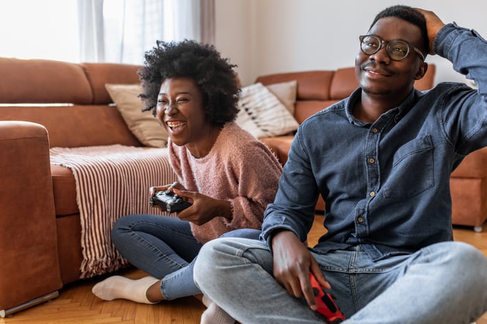 A couple playing a console video game together.