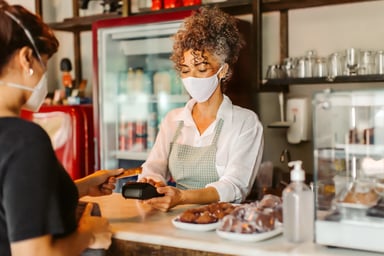 A person paying with a credit card in a cafe.