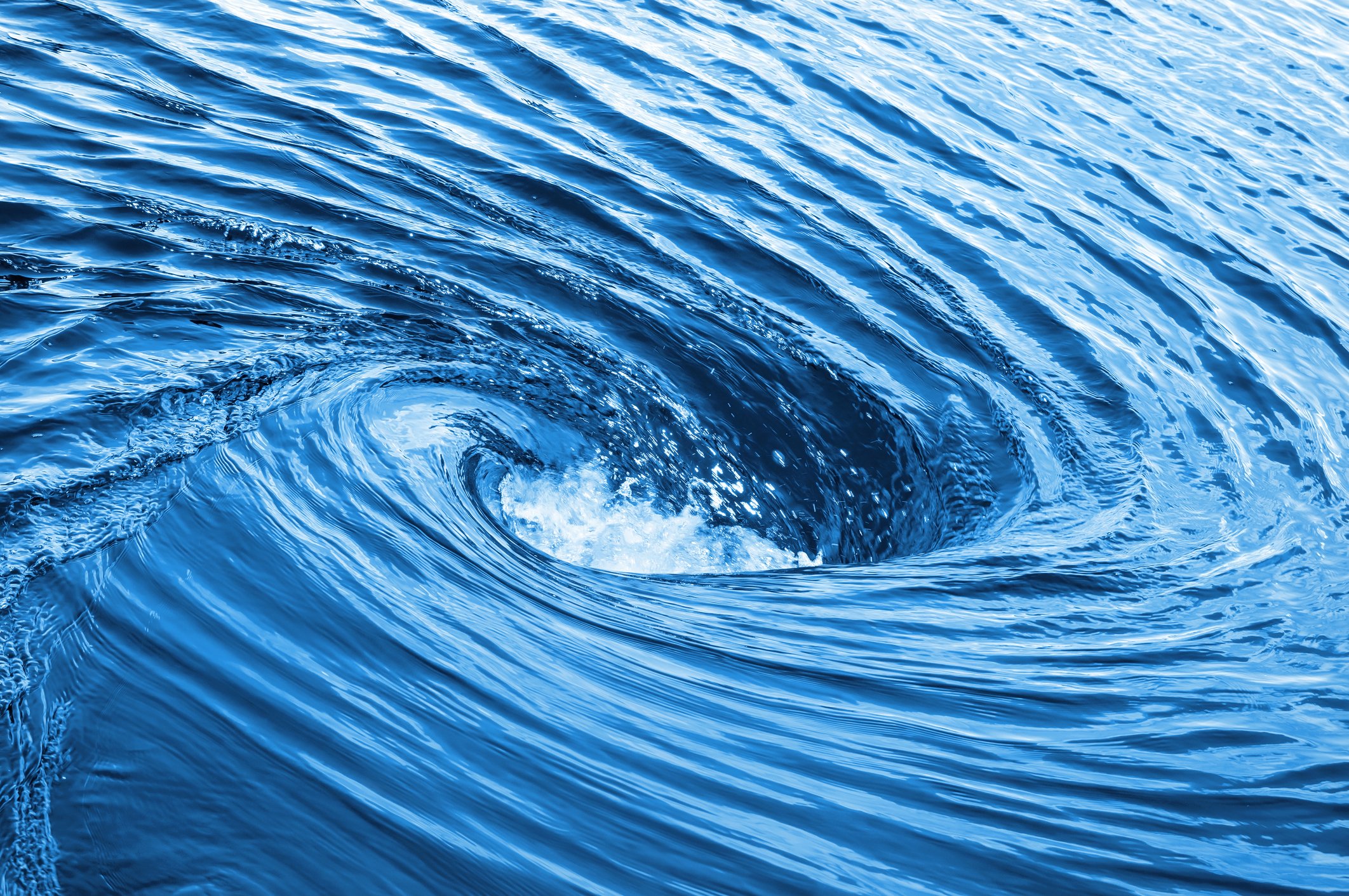 A raging whirlpool in a dark pool of water.