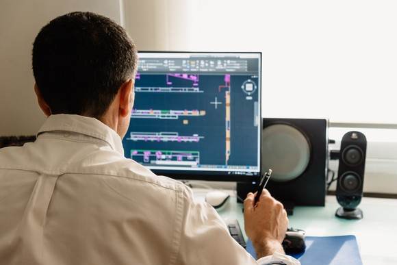 Person using auto CAD software on computer. 