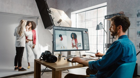 A person uses a computer to look at images taken during a photo shoot.