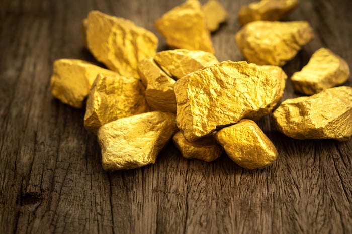 Gold nuggets on a wooden table.