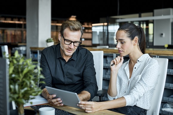 Two people looking at a tablet.