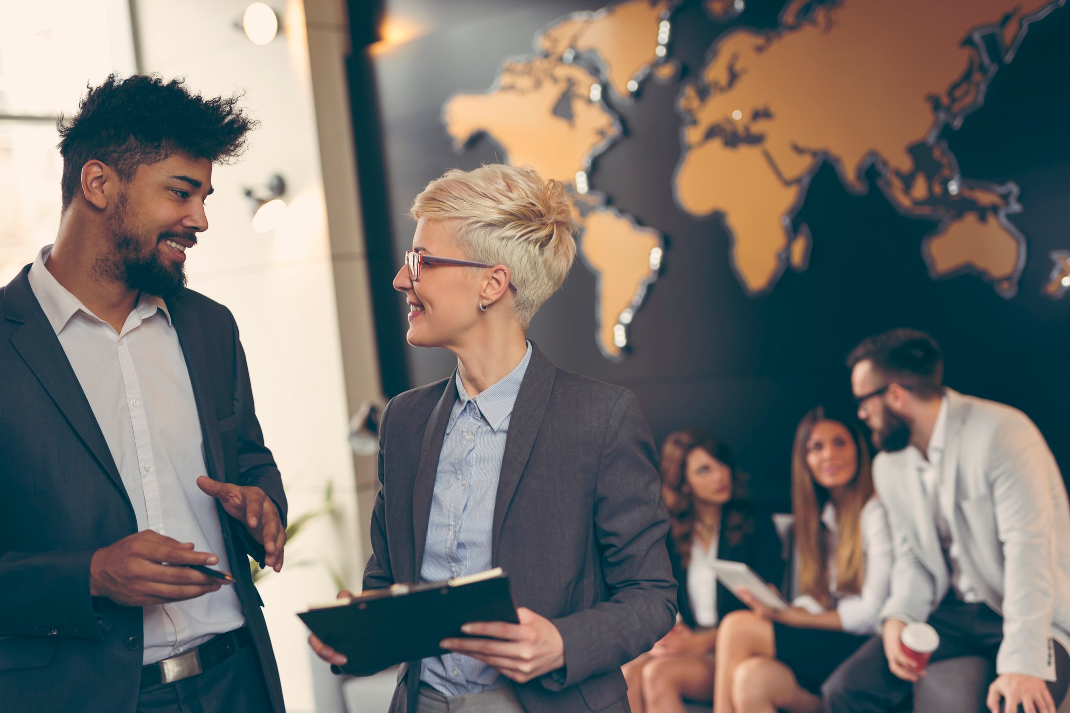 Diverse group of businesspeople in front of a map of the globe. 