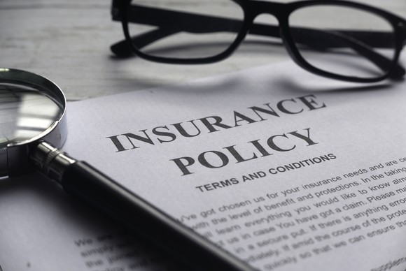 An insurance policy with eyeglasses and a magnifying glass.