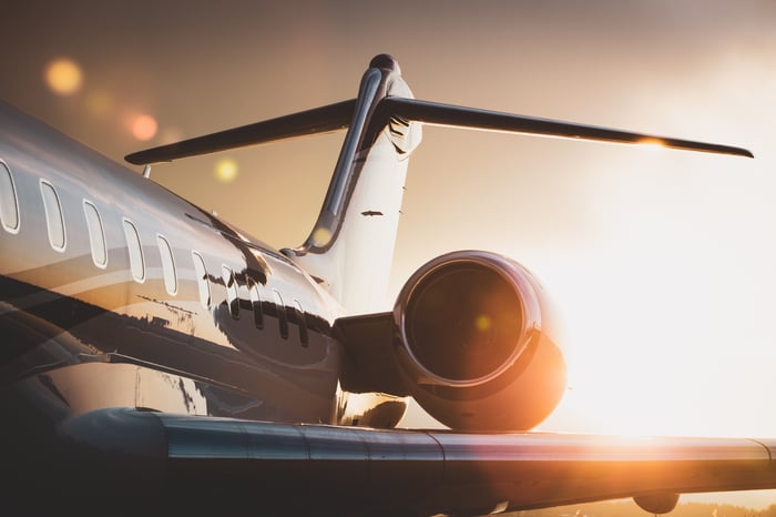 The rear fuselage of a passenger jet, backlit by the sun.