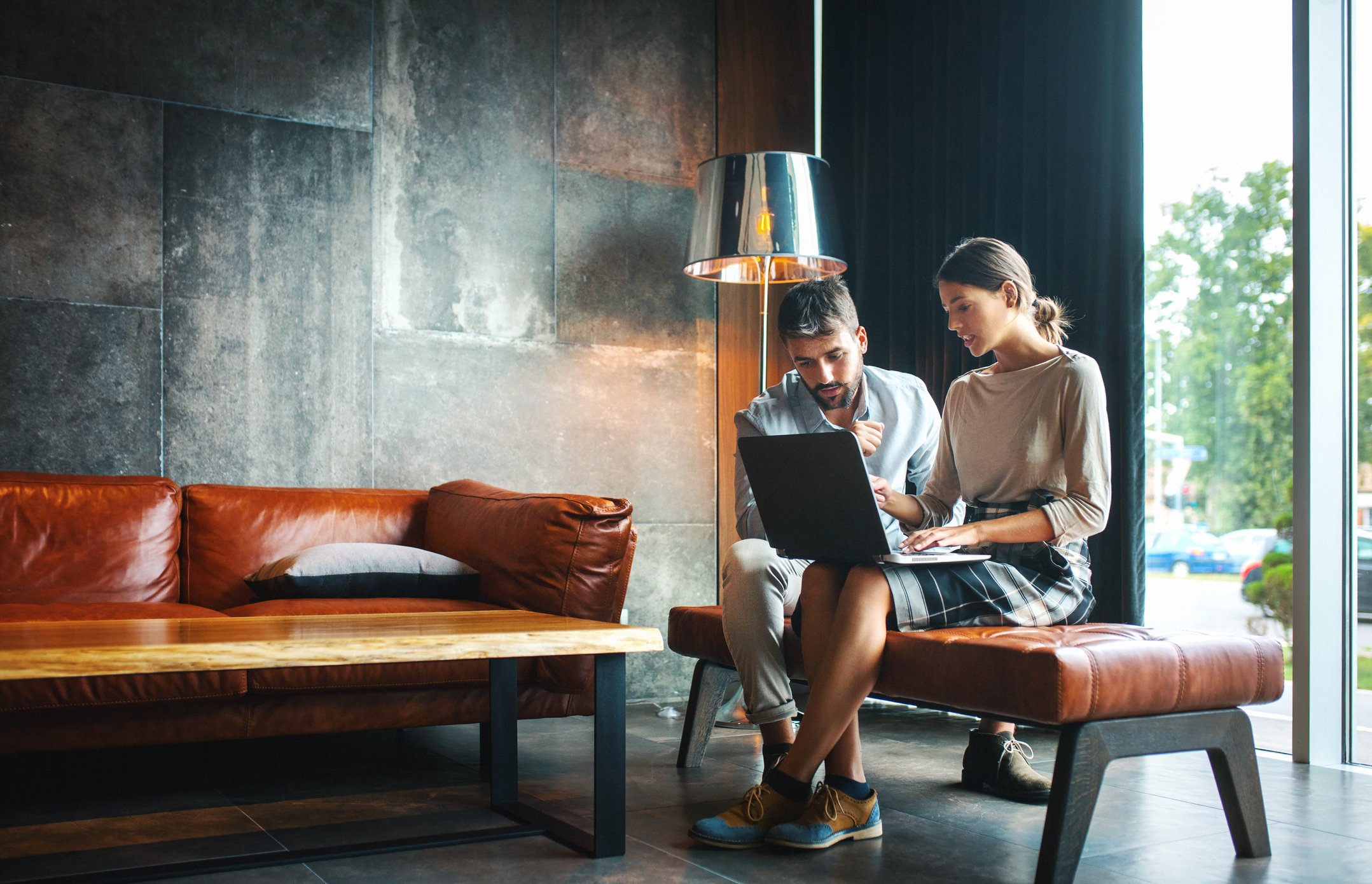 Two people looking at computer in a luxurious home.