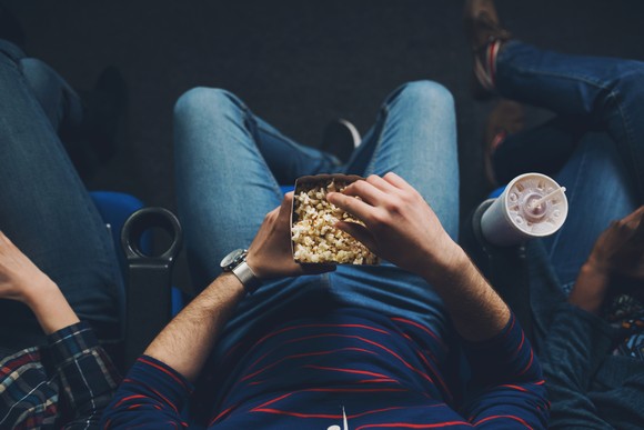 Person enjoying snacks at the movie theater.