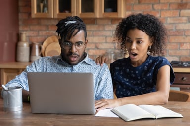 Shocked couple looking at computer.