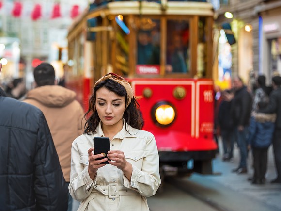 A person looking at a phone on a city street in Istanbul, Turkey.