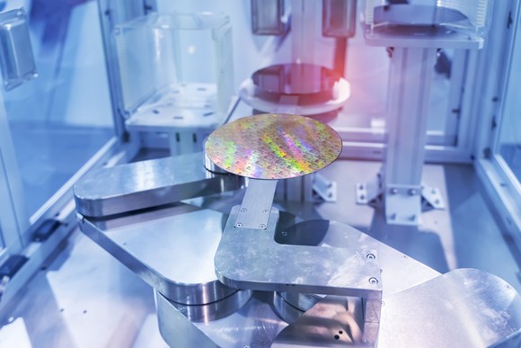 A circular silicon wafer in a semiconductor equipment chamber. 