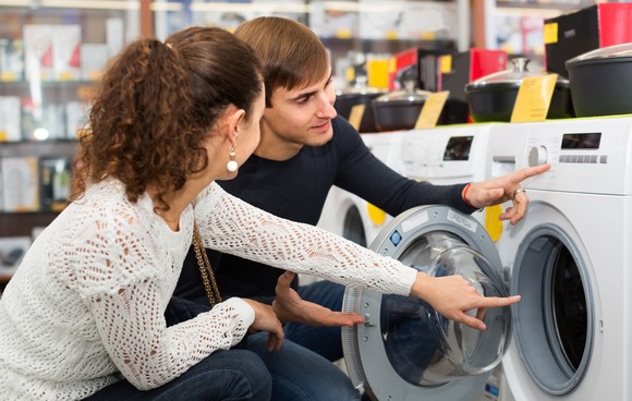 Two people shopping for clothes washer.