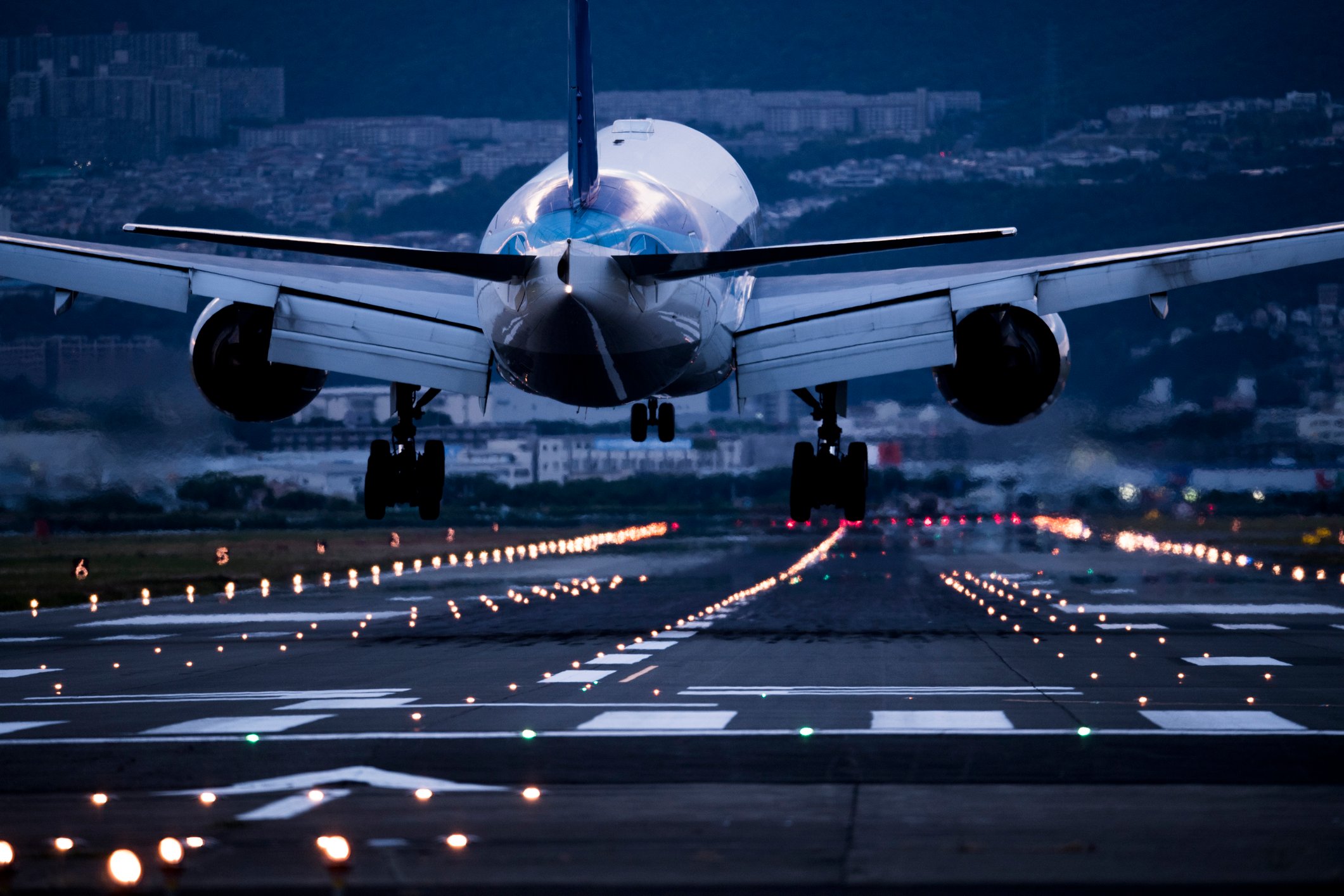 An aircraft taking off over a well-lit runway.