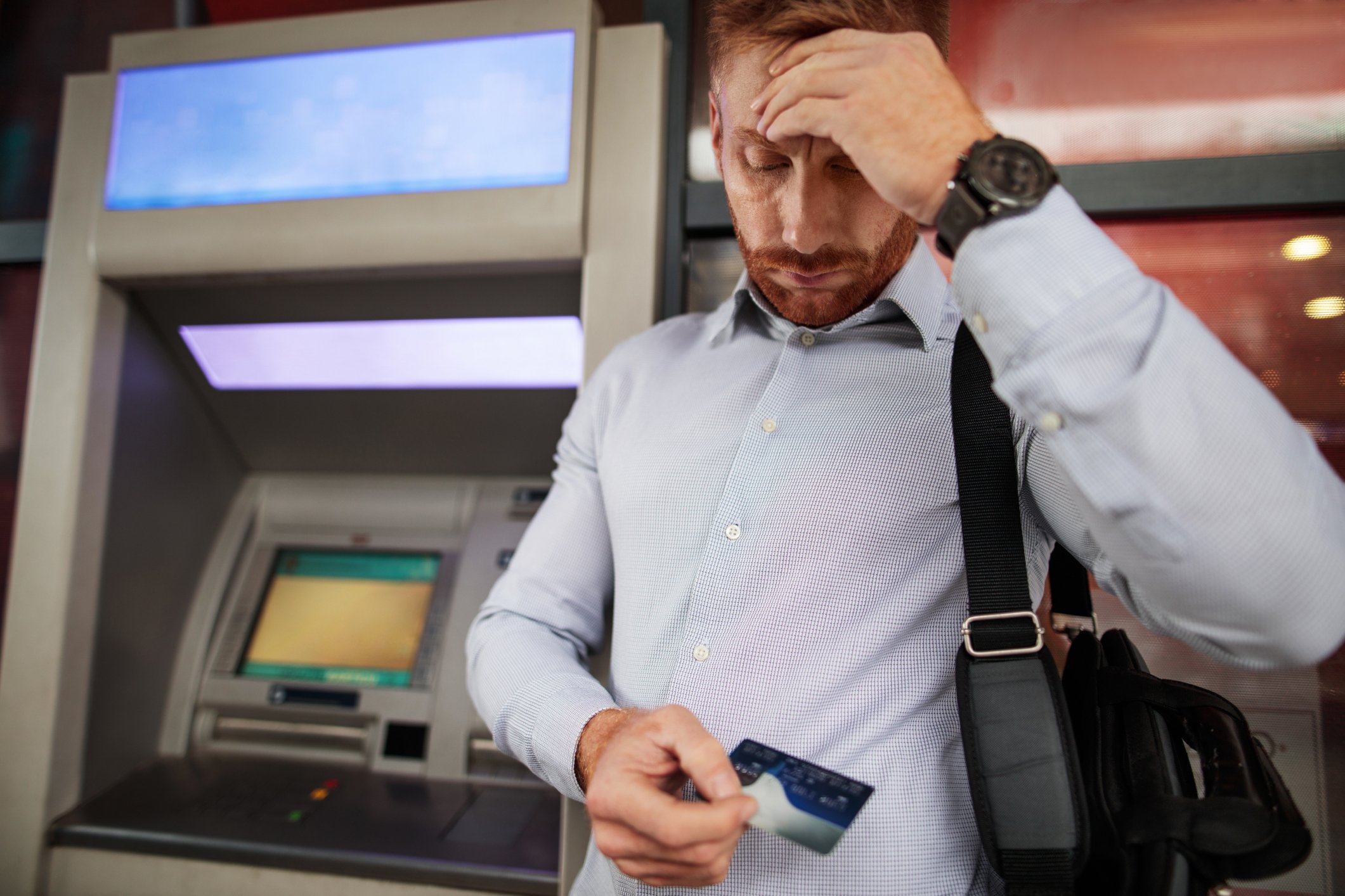 Person looking down at credit card with a stressed look.