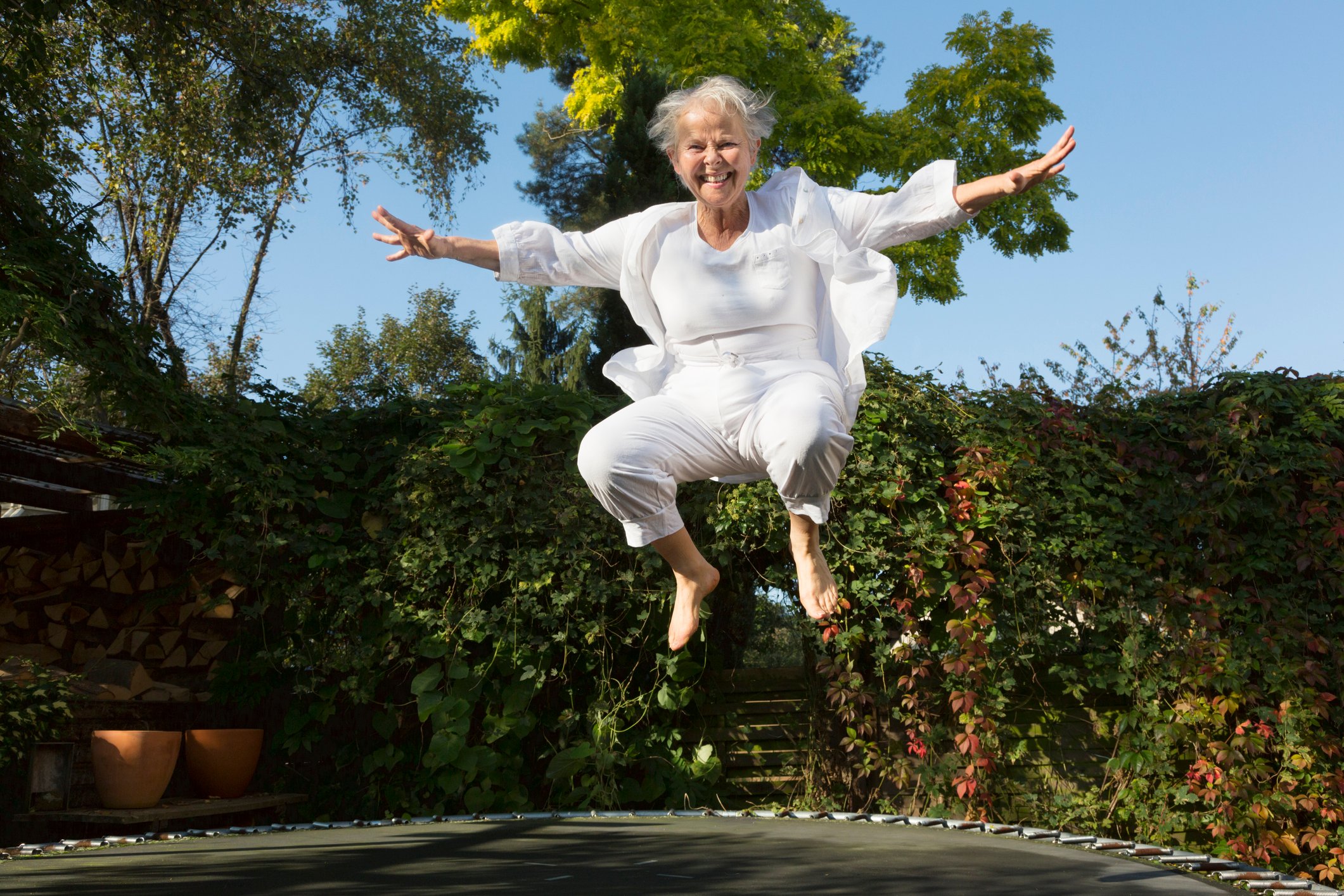 Older person bouncing on a trampoline. 