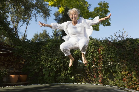 Older person bouncing on a trampoline. 