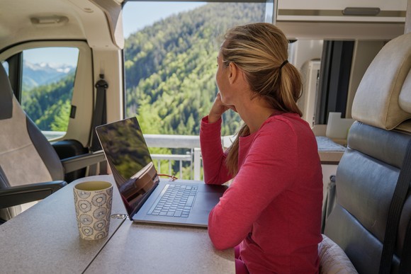 A person working from an RV at a scenic spot.