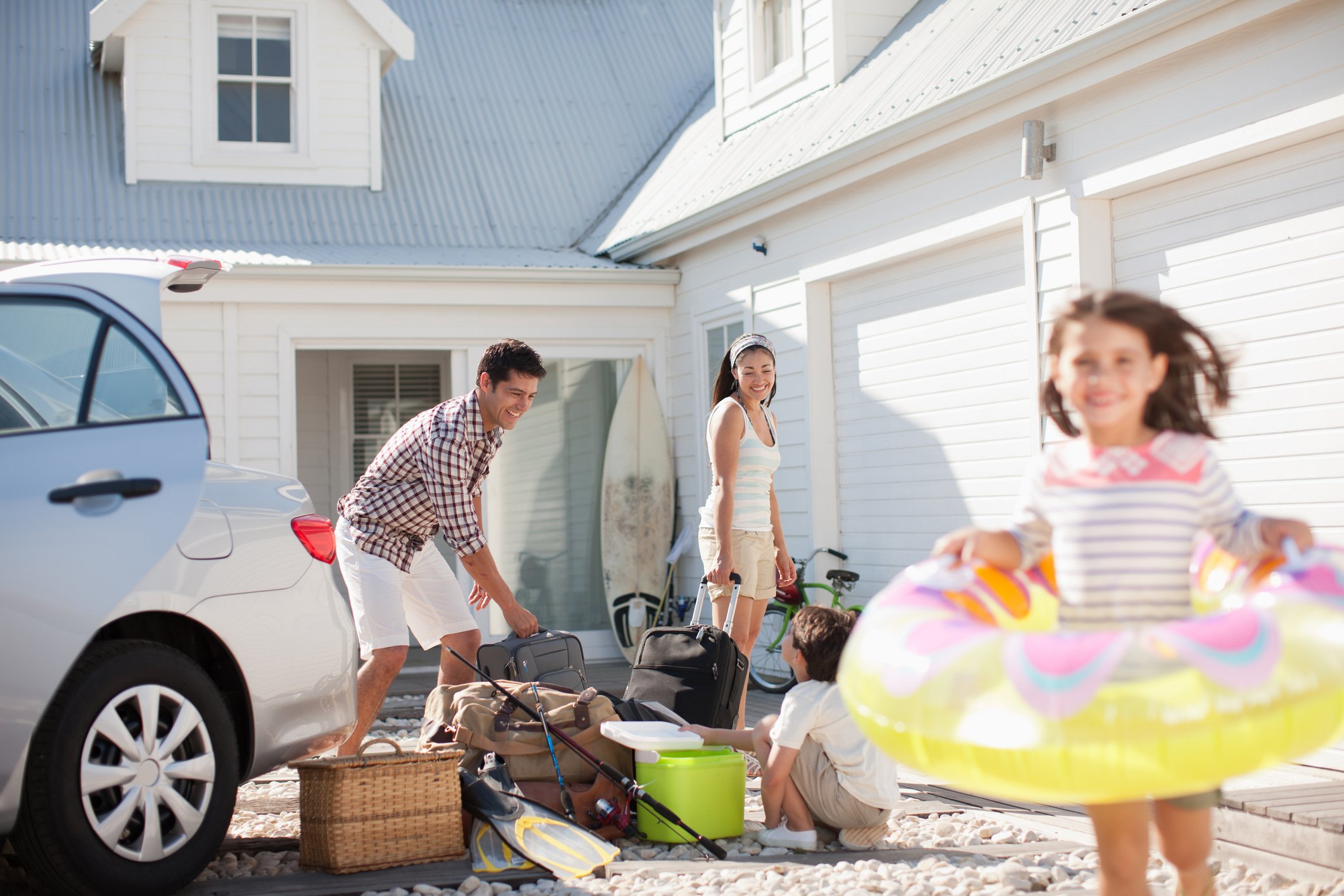 A family unloading luggage from their car.