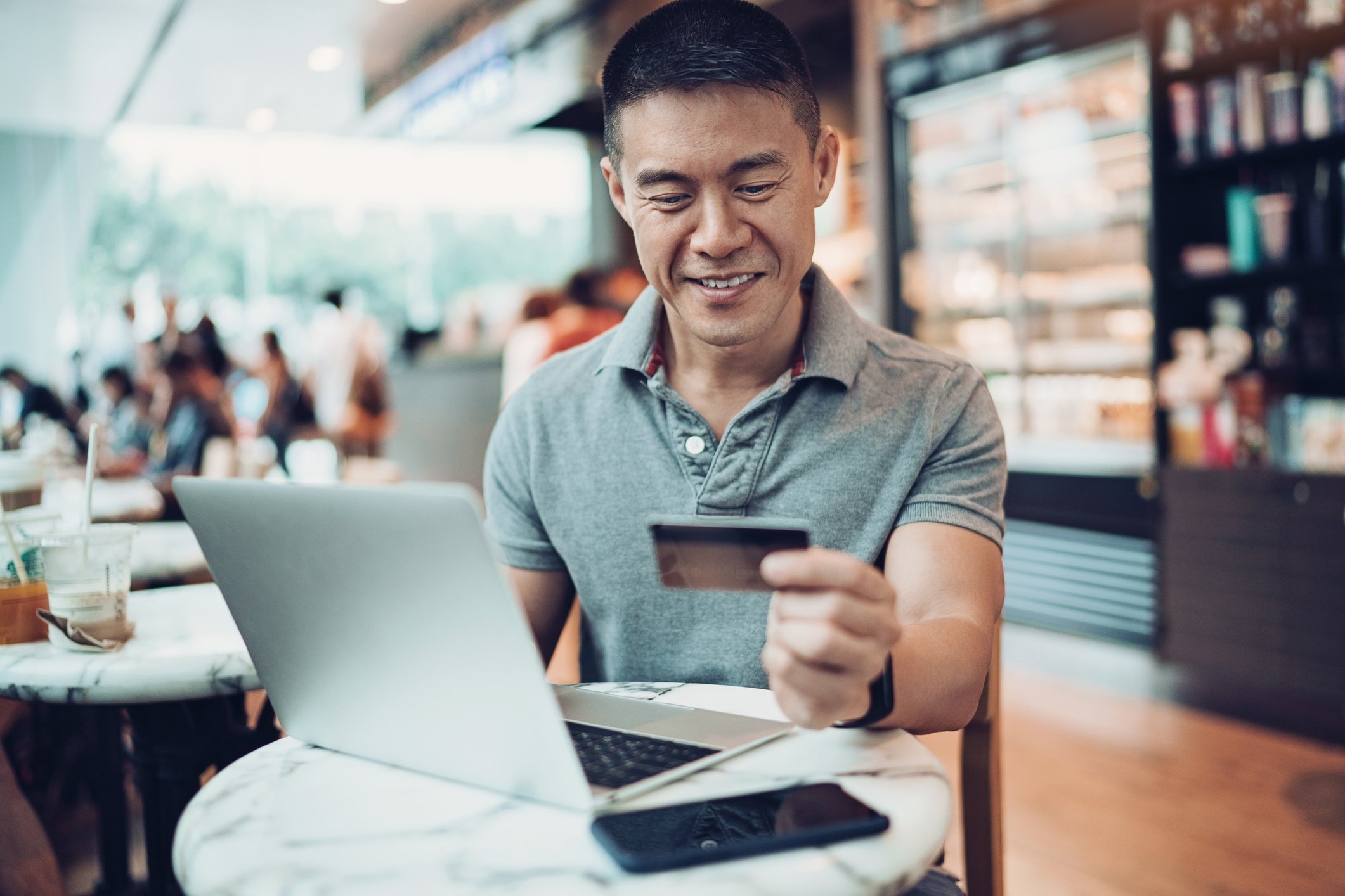 An e-commerce customer shops online while holding a credit card.