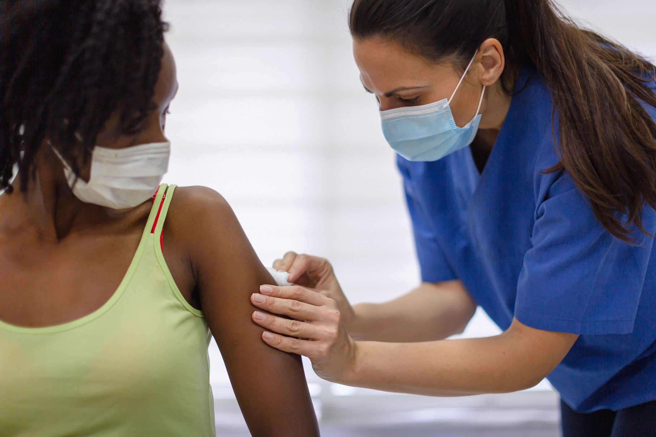 A healthcare worker vaccinates someone in a medical office.